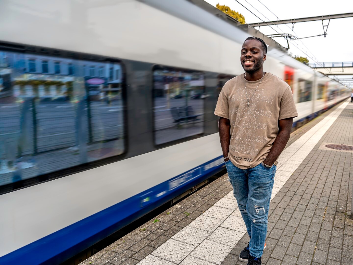 DeanC op perron met achter zich een trein die voorbij rijdt